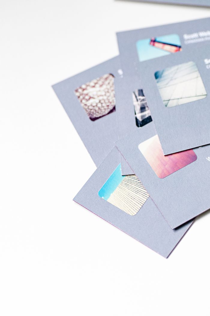 Vue en plongée de cartes de visite abstraites au design créatif avec découpes sur fond blanc.